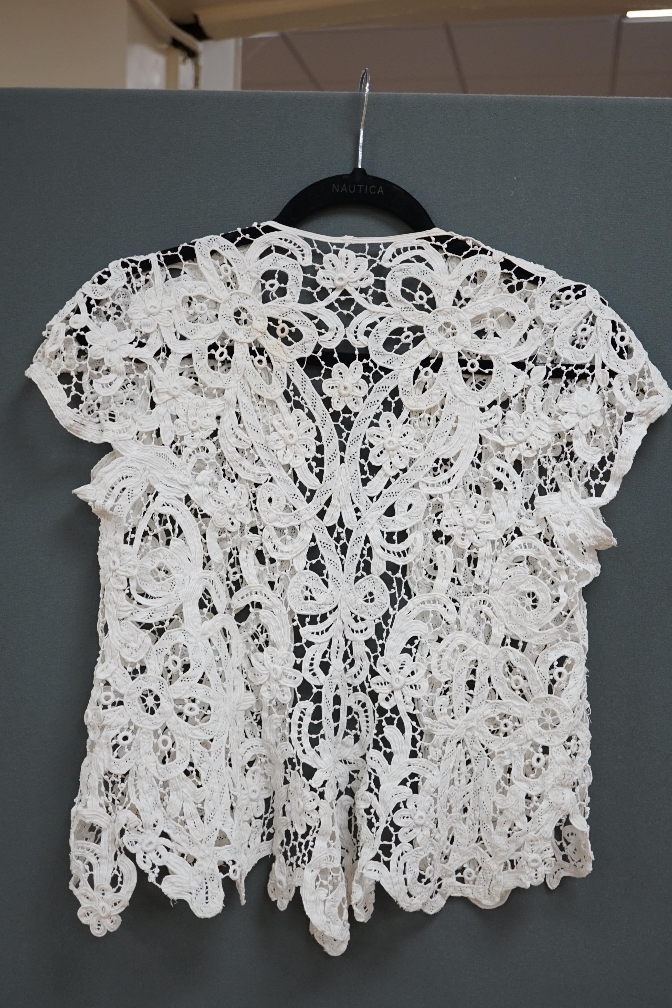 An Edwardian ladies white lace bolero, a tape lace Edwardian cap sleeve bolero with hand sewn bracts, attaching the tape lace together, possibly part of a wedding dress or summer dress, back under arm width 36cm. Conditi